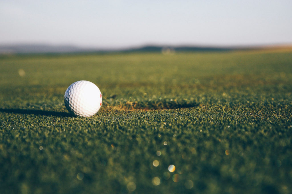 golf ball next to hole